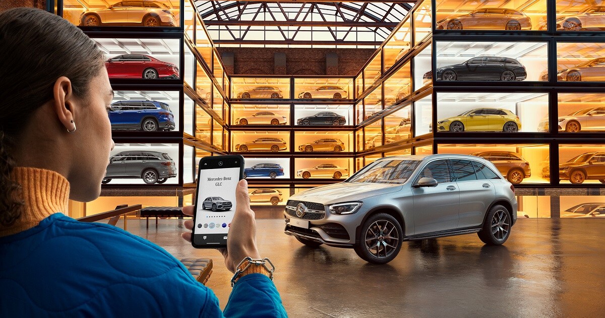 Renting aan 4,99% op onze stockvoertuigen. Een persoon die een mobiel apparaat gebruikt in een virtuele showroom.