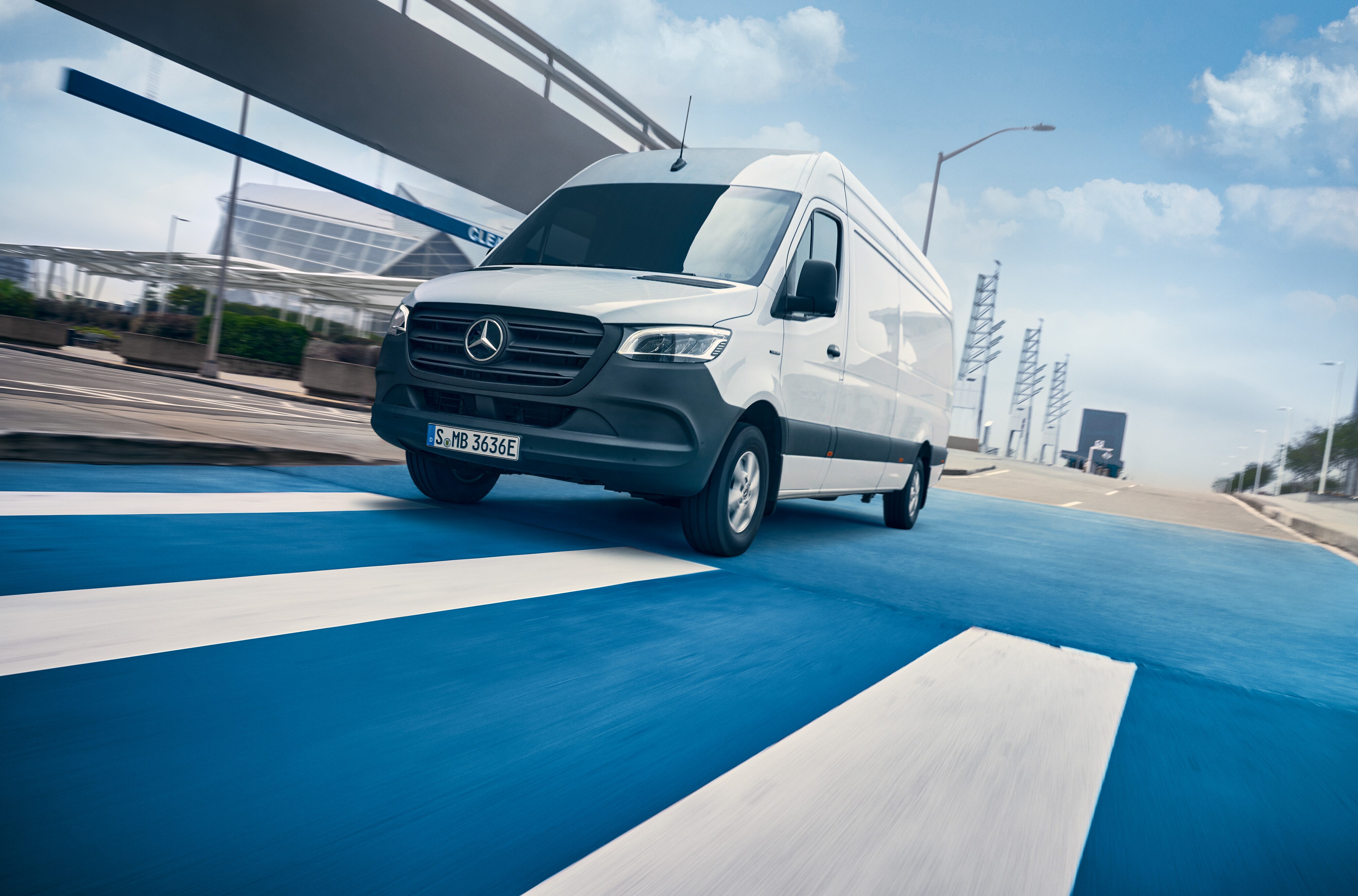Mercedes-Benz | Van ServiceCare | Pack Pack Maintenance Une Mercedes-Benz Sprinter blanche roule sur une route dans une ville.